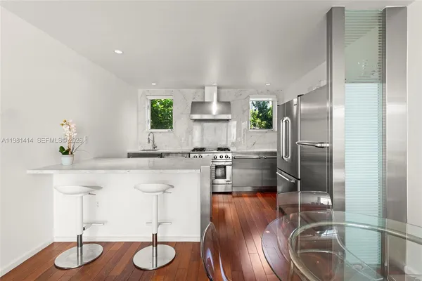 a kitchen with stainless steel appliances granite countertop a sink refrigerator and cabinets