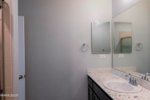 a bathroom with a granite countertop sink and a mirror