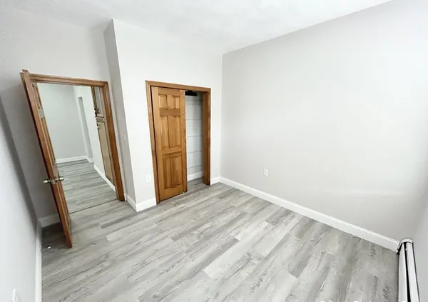 an empty room with wooden floor and a window