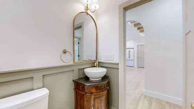 a bathroom with a granite countertop sink a toilet and a mirror