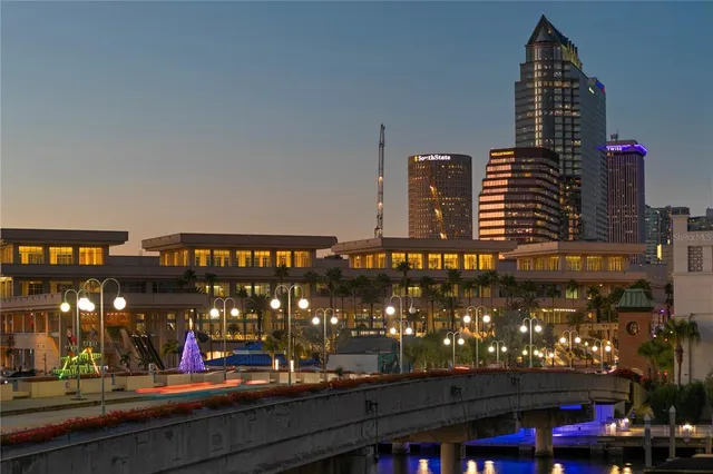 a living room with couches a dining table and chairs with wooden floor