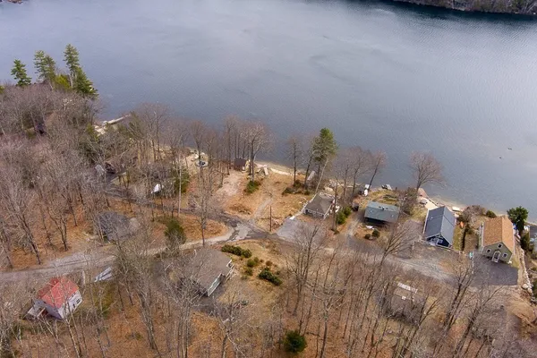an aerial view of ocean with residential houses with outdoor space and seating