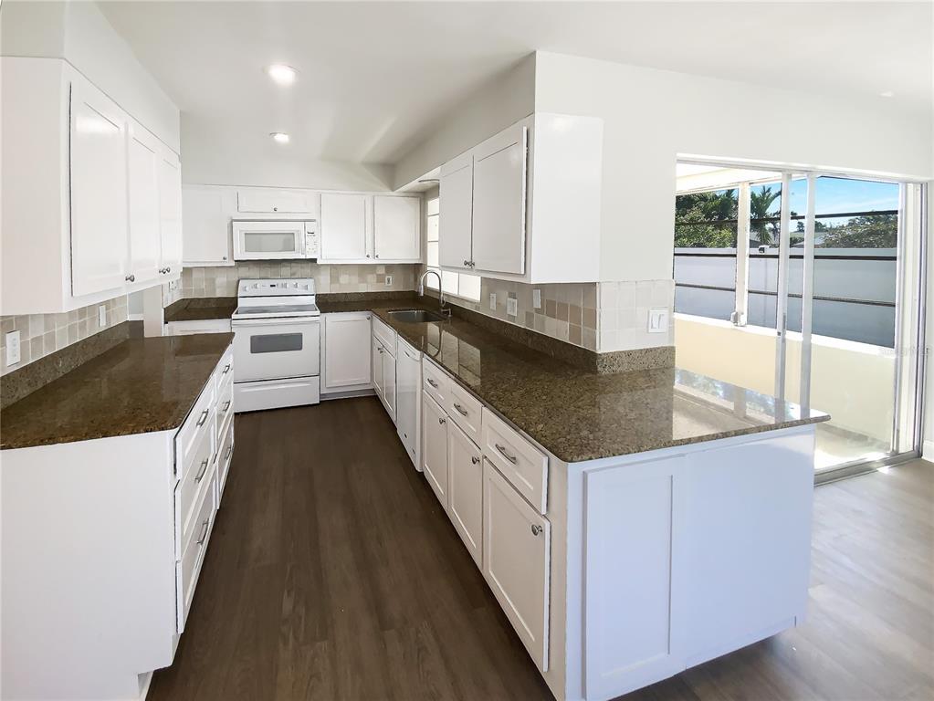 10454 138th Street Largo, FL 33774 - Photo 12 of 35 a kitchen with stainless steel appliances granite countertop a lot of counter space and wooden floors
