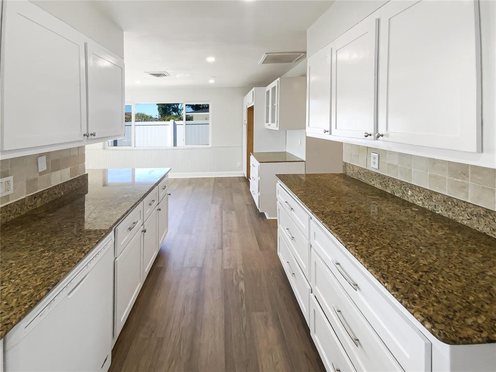 10454 138th Street Largo, FL 33774 - Photo 14 of 35 a large kitchen with kitchen island granite countertop wooden cabinets and granite counter tops