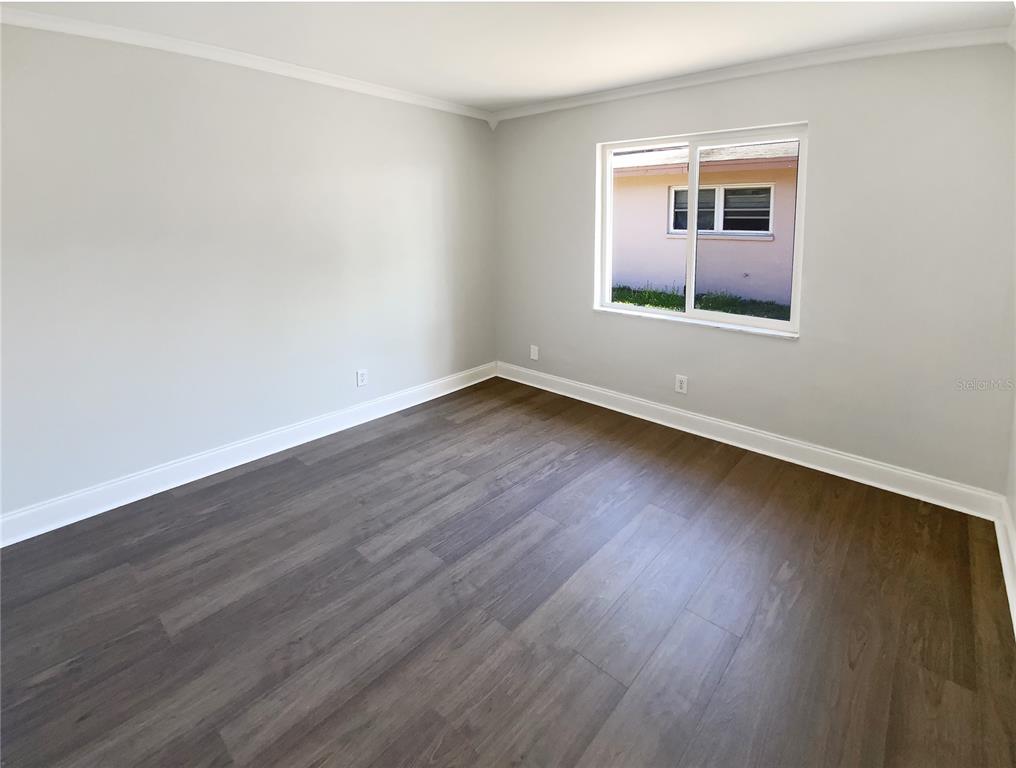 10454 138th Street Largo, FL 33774 - Photo 24 of 35 a view of an empty room with wooden floor and a window