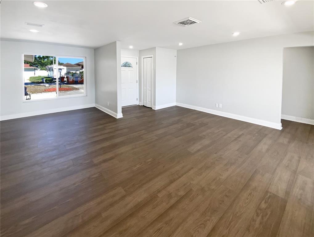 10454 138th Street Largo, FL 33774 - Photo 9 of 35 an empty room with wooden floor and windows