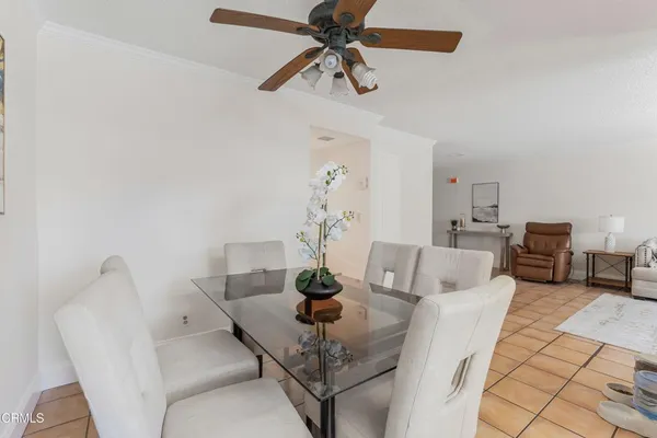 a view of a dining room with furniture and a chandelier fan