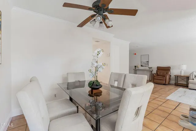 a view of a dining room with furniture and a chandelier fan