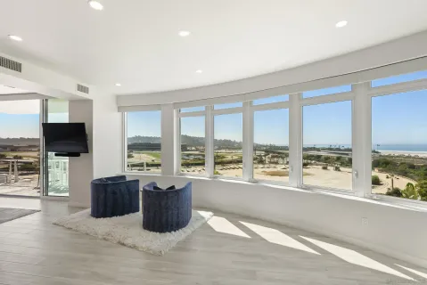 a living room with furniture tv and large windows
