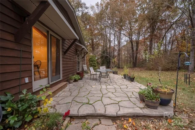 a view of a patio with table and chairs and wooden fence