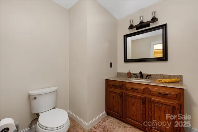 a bathroom with a toilet a sink and mirror