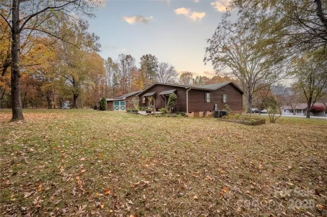 a front view of a house with a yard covered with snow and trees