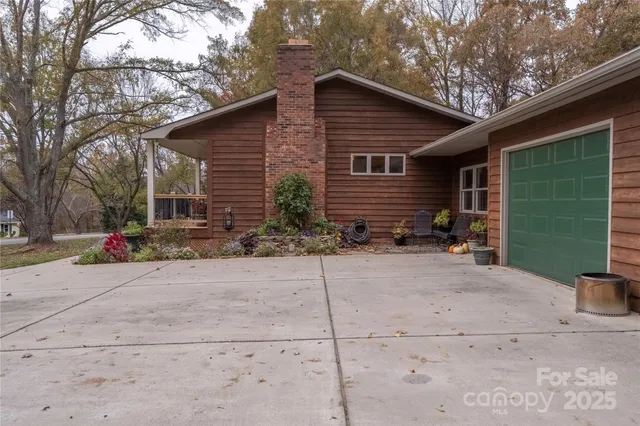 a backyard of a house with plants and a tree