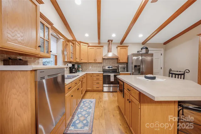 a kitchen with a sink a counter top space stainless steel appliances a window and cabinets