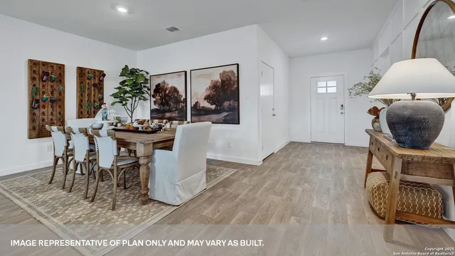 a dining room with furniture potted plants and wooden floor