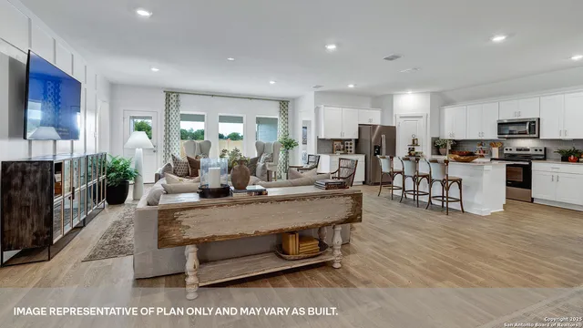a living room with furniture a wooden floor and a potted plant