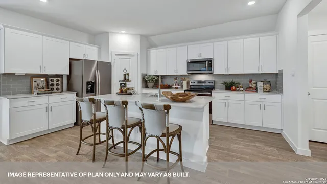 a kitchen with stainless steel appliances granite countertop a refrigerator a stove a sink a dining table and chairs