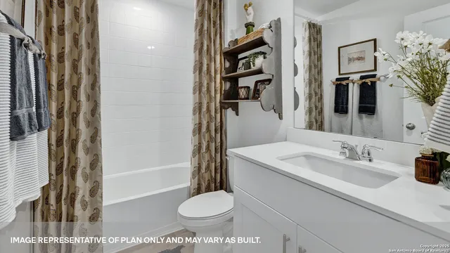 a view of a backyard with plants and large tree