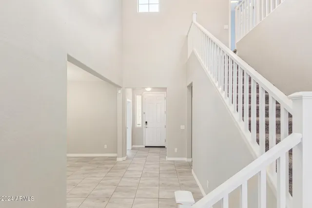 an empty room with chandelier and windows