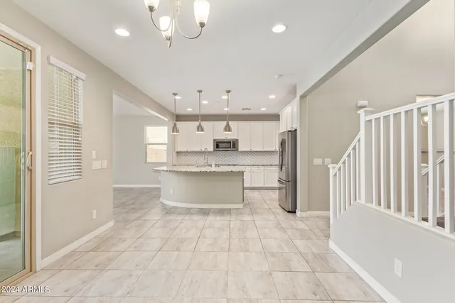 a kitchen with stainless steel appliances granite countertop a sink a stove a microwave oven a refrigerator with white cabinets and granite countertops