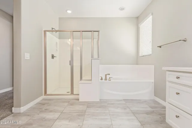 a bathroom with a bathtub shower sink vanity and toilet
