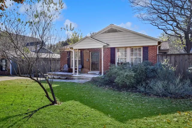 a view of a house with backyard and a tree