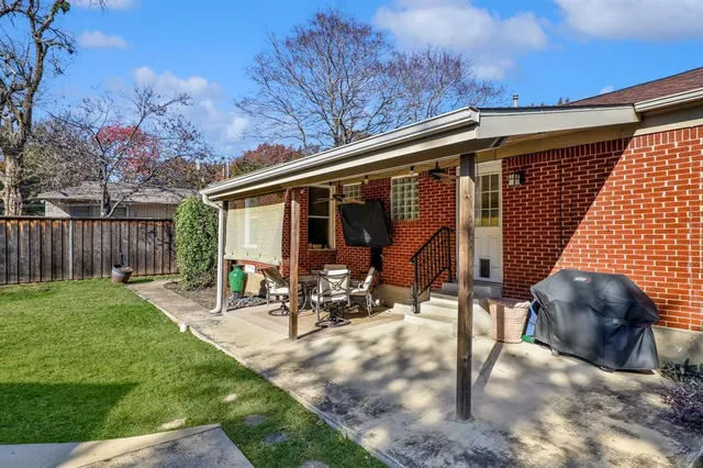 a view of a patio with table and chairs and wooden fence