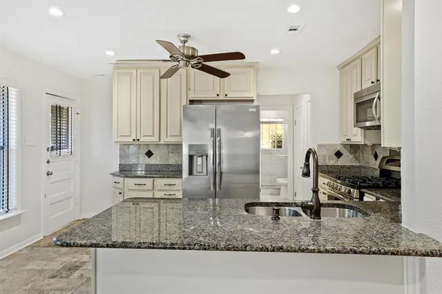 a kitchen with kitchen island granite countertop a counter top space appliances and cabinets