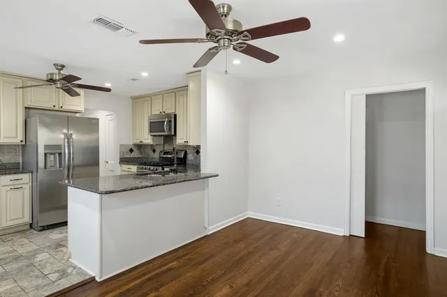 a kitchen with stainless steel appliances granite countertop a refrigerator and a sink