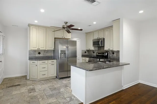 a kitchen with stainless steel appliances granite countertop a stove refrigerator sink and microwave