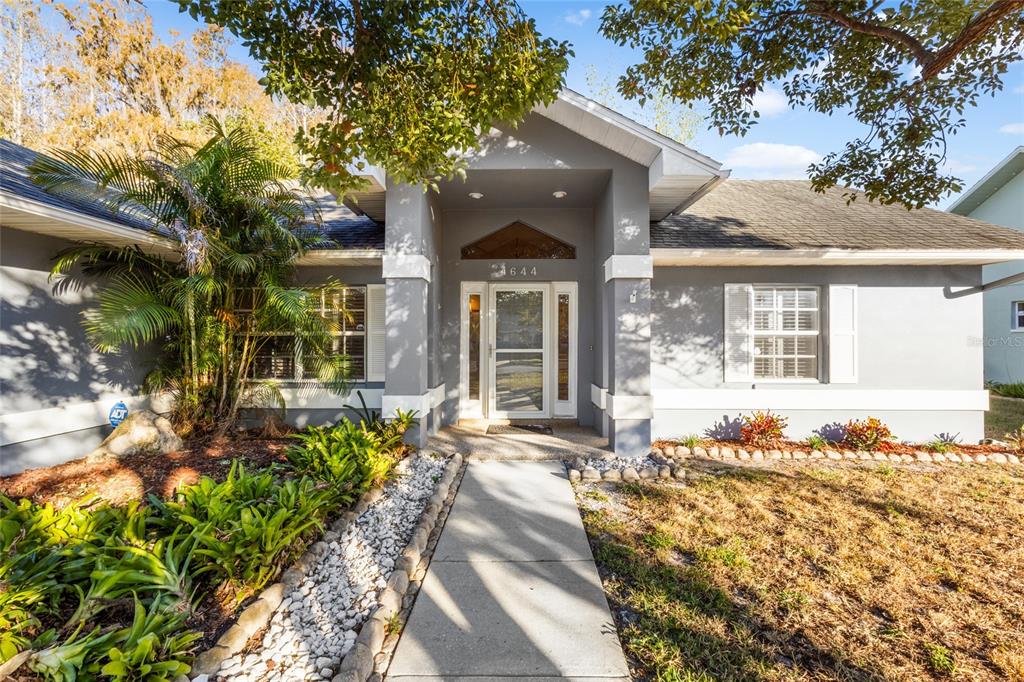 a front view of a house with a large tree and a yard