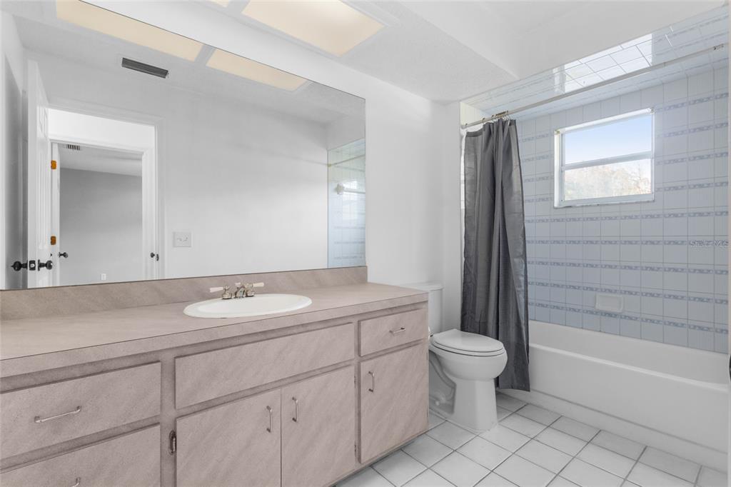4644 Sawgrass Boulevard New Port Richey, FL 34653 - Photo 12 of 34 a bathroom with a granite countertop sink a toilet mirror and bathtub