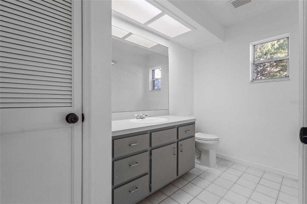 4644 Sawgrass Boulevard New Port Richey, FL 34653 - Photo 18 of 34 a bathroom with a toilet sink and mirror
