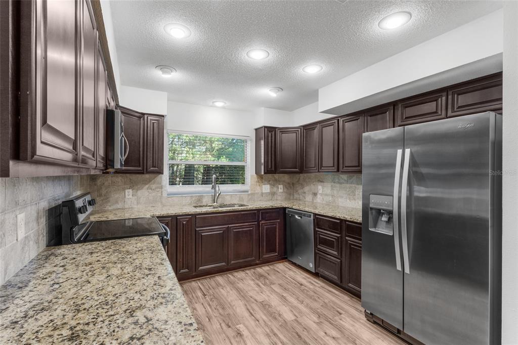 4644 Sawgrass Boulevard New Port Richey, FL 34653 - Photo 7 of 34 a kitchen with stainless steel appliances granite countertop a sink a stove and a refrigerator