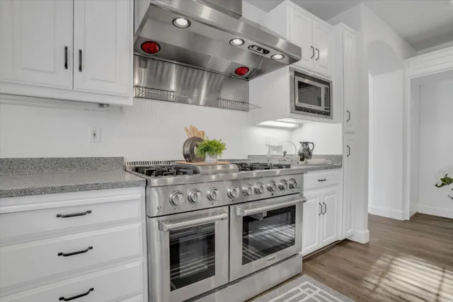a kitchen with stainless steel appliances granite countertop a stove and a microwave