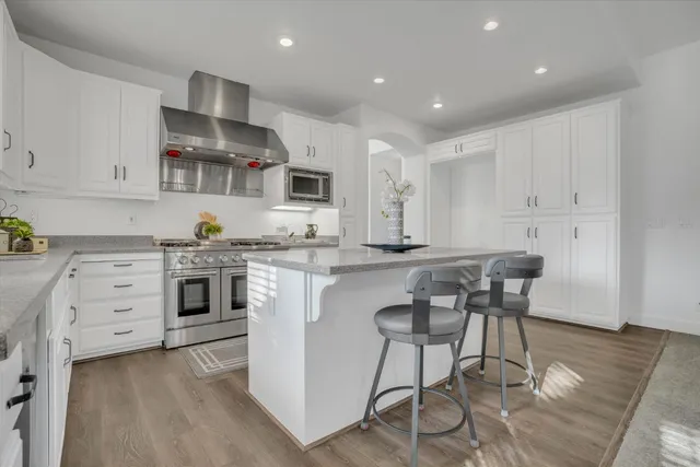 a kitchen with white cabinets and stainless steel appliances