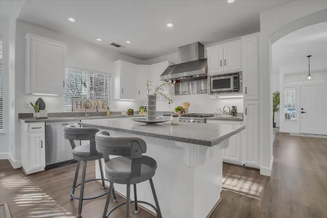 a kitchen with stainless steel appliances granite countertop a sink and a refrigerator
