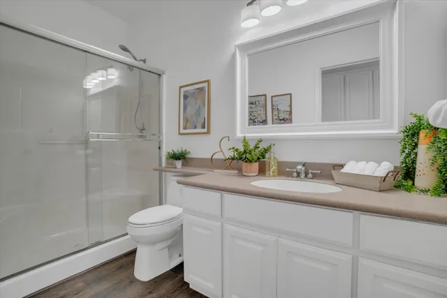 a bathroom with a granite countertop sink a toilet and a mirror