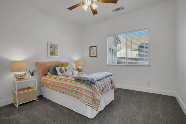 a spacious bedroom with a bed and a chandelier