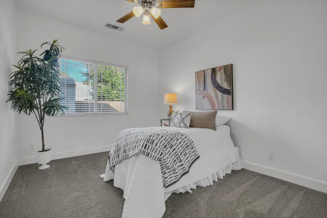 a bedroom with a bed and a potted plant