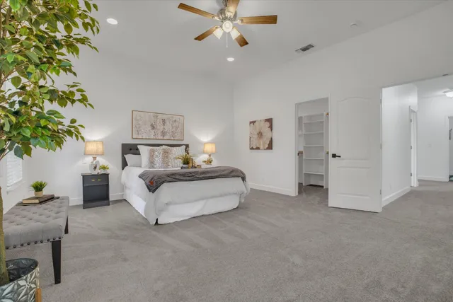 a spacious bedroom with a bed and a chandelier