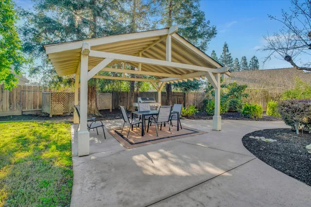 a view of a patio with a table and chairs under an umbrella