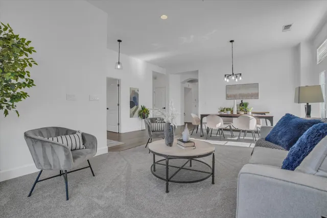 a living room with furniture and a chandelier