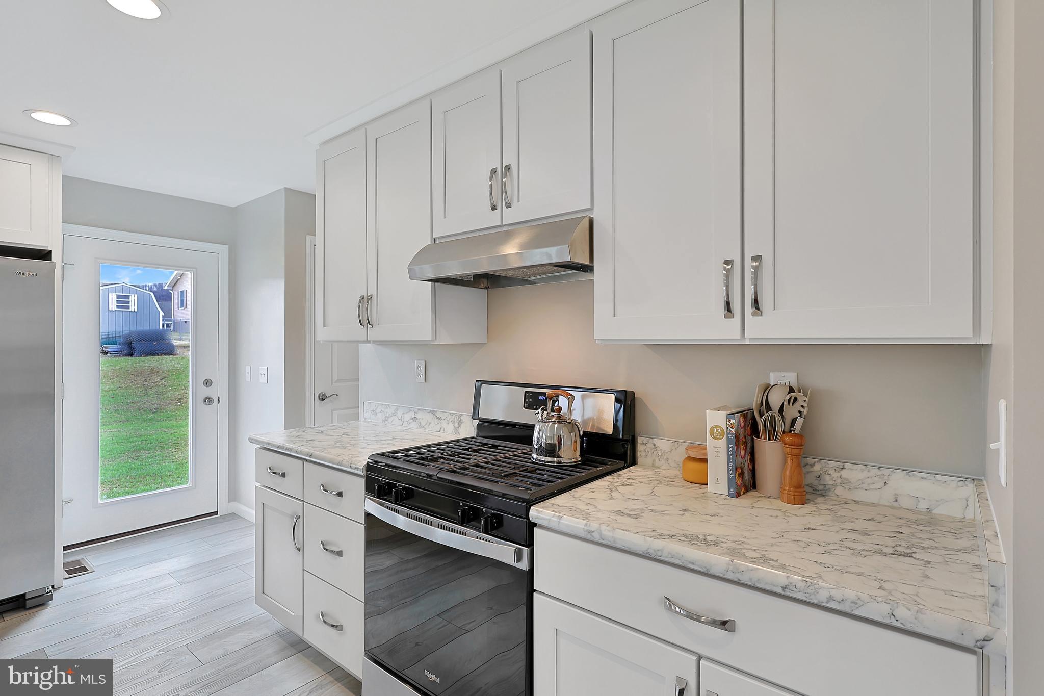 1525 Beacon Street Keyser, WV 26726 - Photo 13 of 67 a kitchen with stainless steel appliances granite countertop a stove and a white cabinets