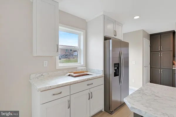 a living room with stainless steel appliances kitchen island wooden floors and view living room