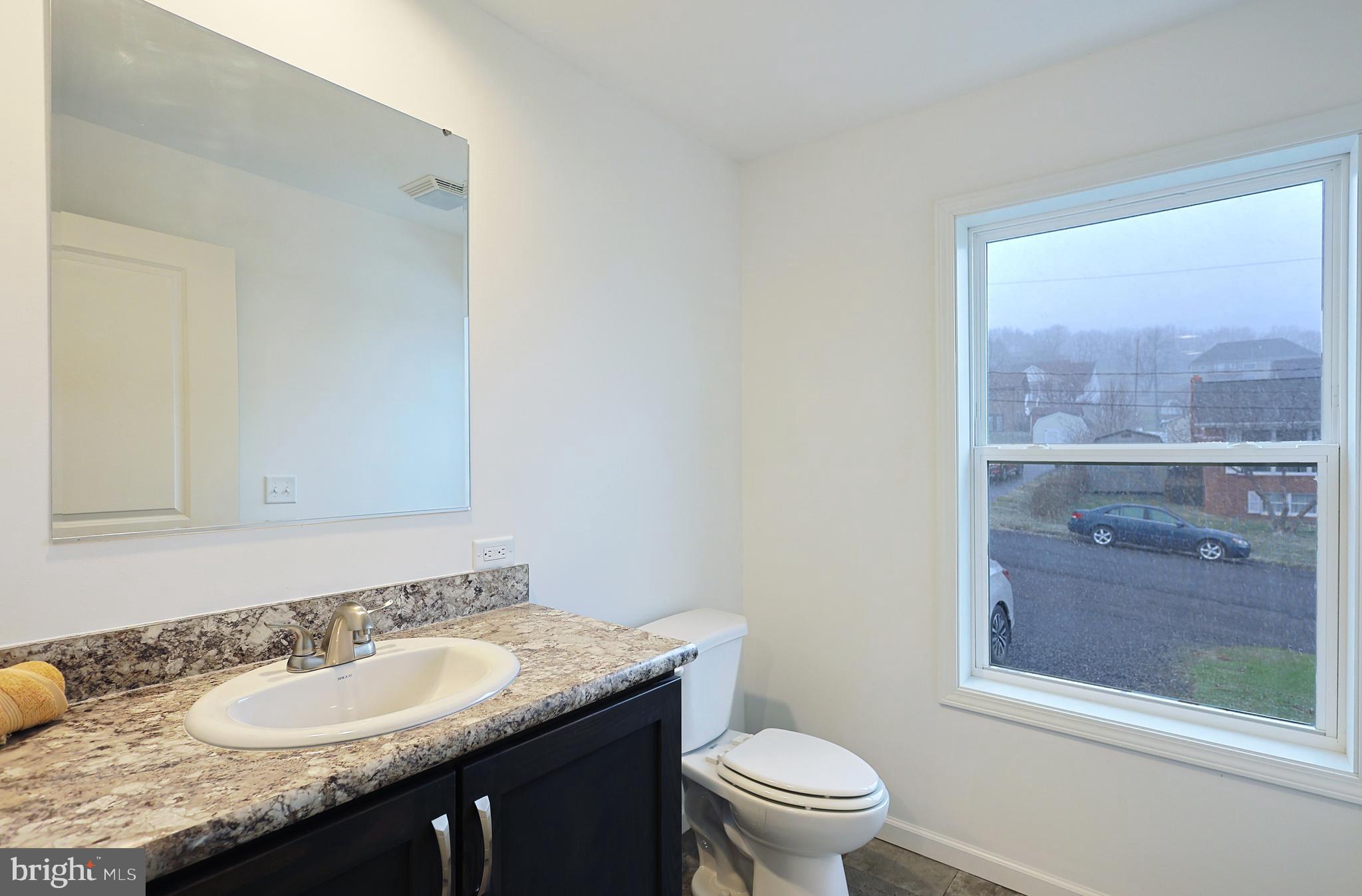 1525 Beacon Street Keyser, WV 26726 - Photo 27 of 59 a bathroom with a granite countertop sink a toilet and a mirror