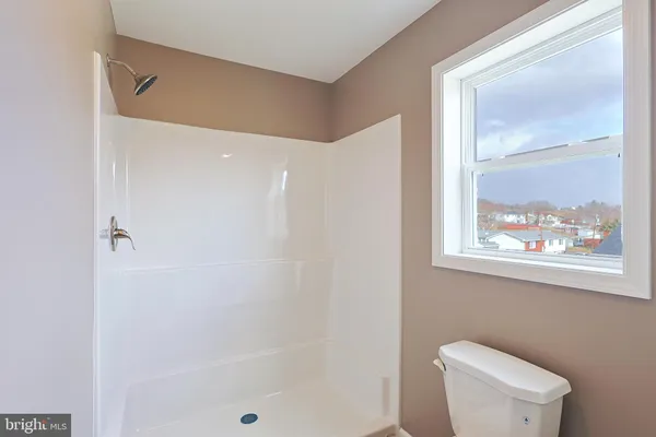 a bathroom with a granite countertop sink a toilet and a mirror