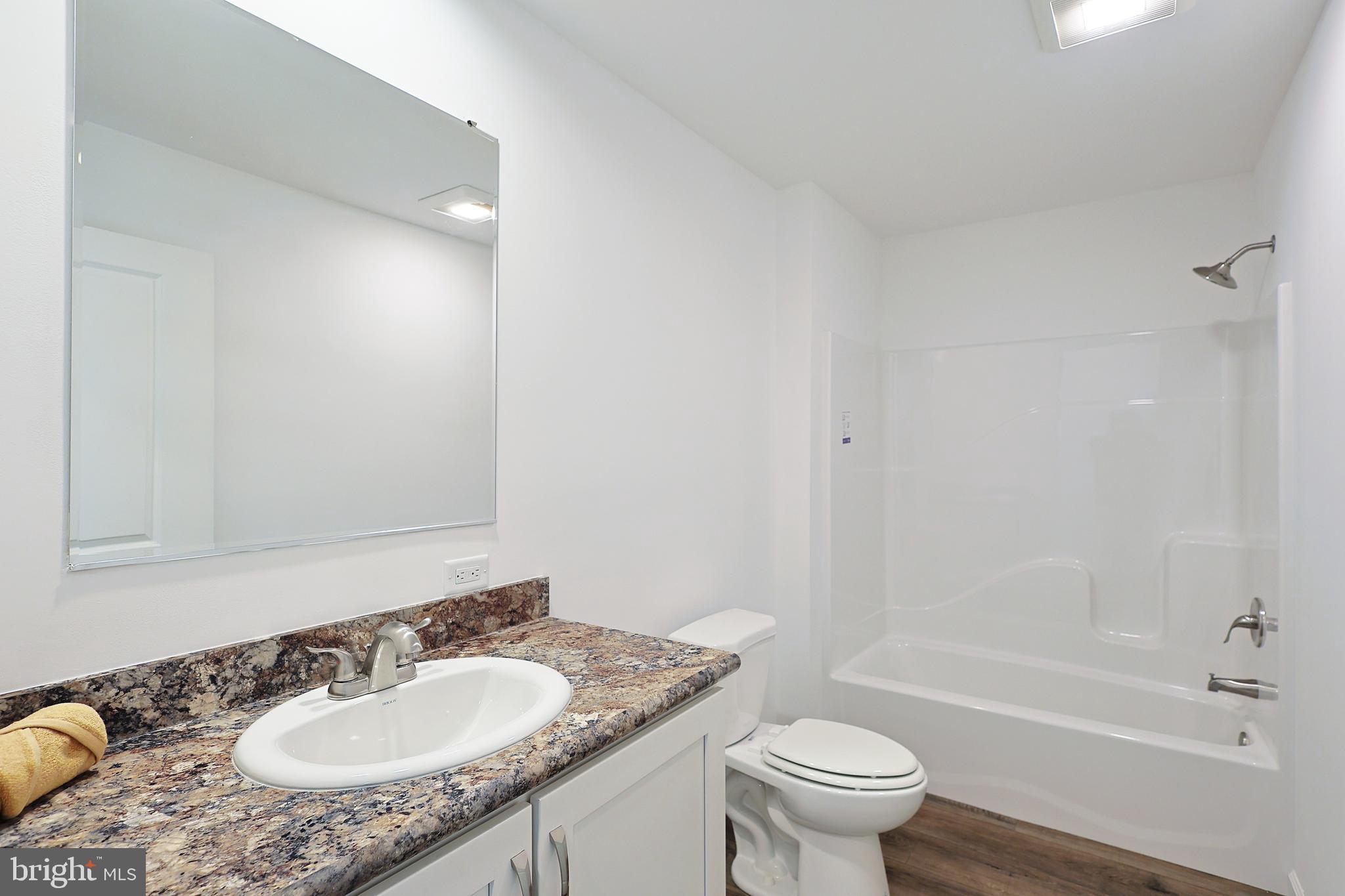 1525 Beacon Street Keyser, WV 26726 - Photo 46 of 59 a bathroom with a granite countertop sink a toilet a mirror and bathtub