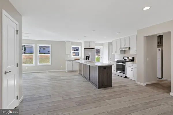 a kitchen with stainless steel appliances granite countertop a stove and a white cabinets