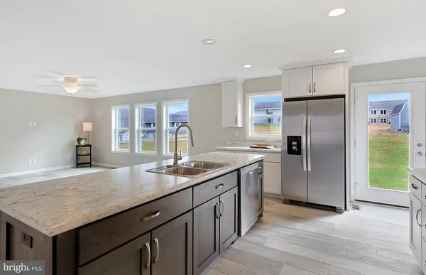 a kitchen with granite countertop white cabinets and stainless steel appliances